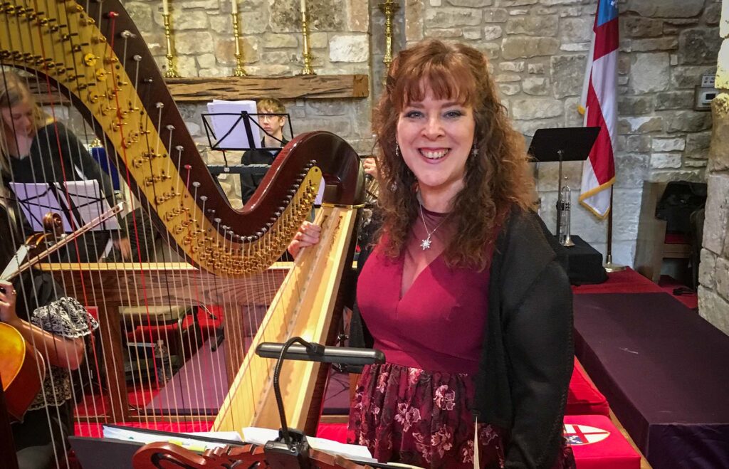 Sherri Stricker next to a Harp